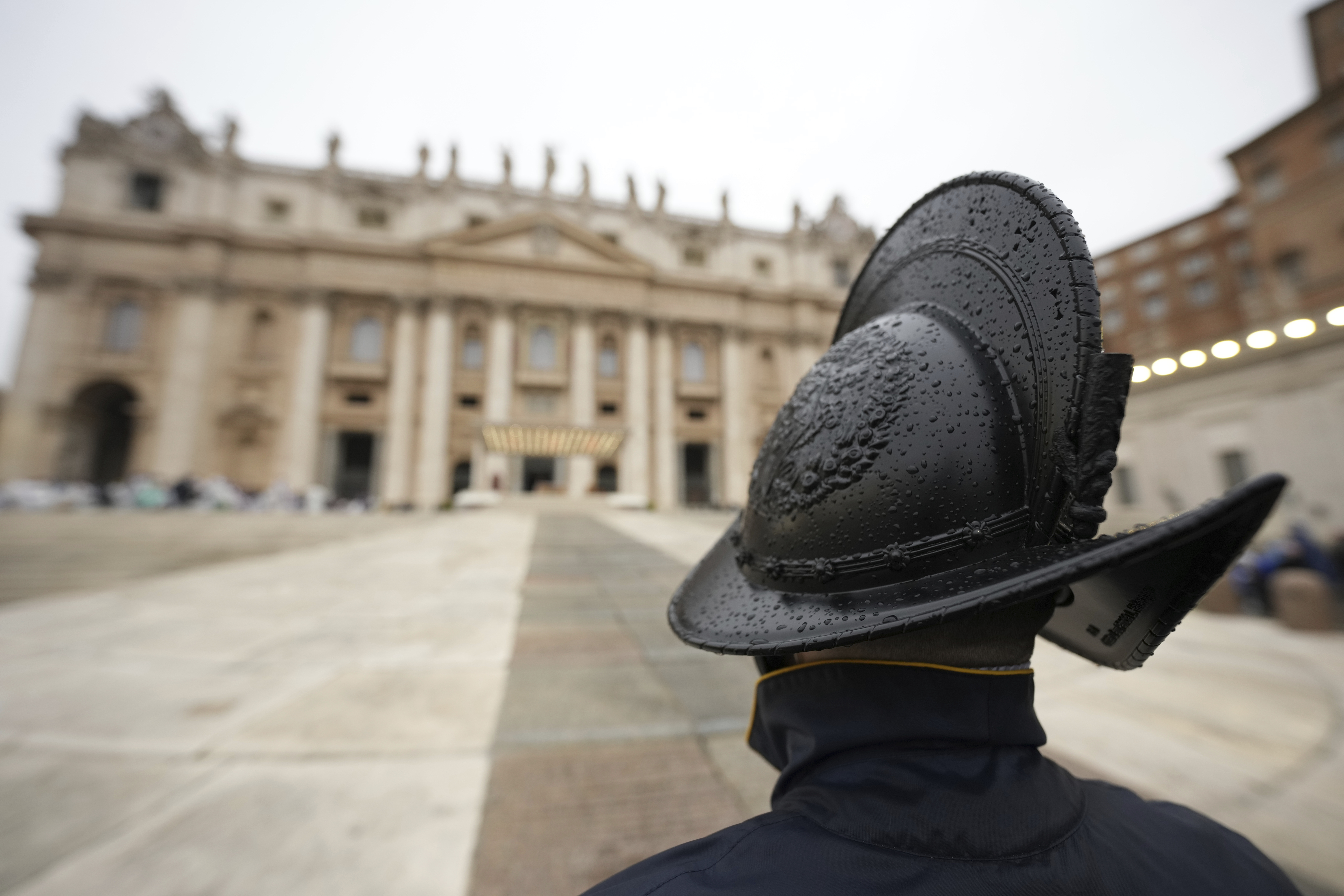 Pontifical Swiss Guards patrol during a mass for the jubilar pilgrims from Naples wait for the start of the celebration on a rainy day in St. Peter's Square at The Vatican, Saturday, March 22, 2025, while Pope Francis is being treated for bilateral pneumonia at Rome's Agostino Gemelli Polyclinic since Feb. 14. (AP Photo/Andrew Medichini)