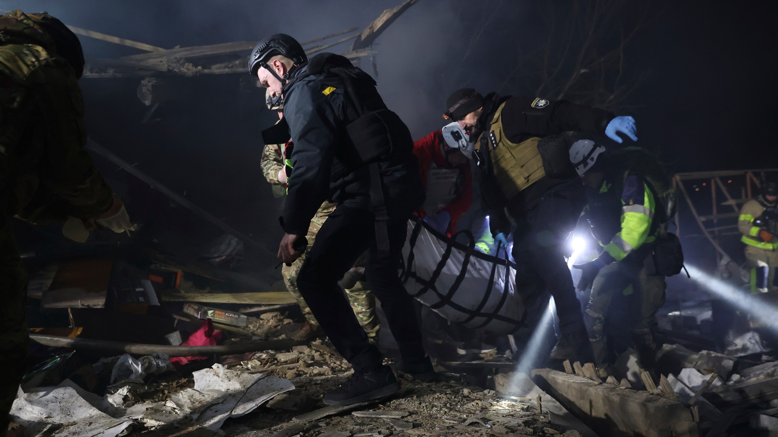 Police officers carry the body of a person killed by a Russian drone strike in a residential neighborhood in Zaporizhzhia, Ukraine, Friday, March 21, 2025. (AP Photo/Kateryna Klochko)