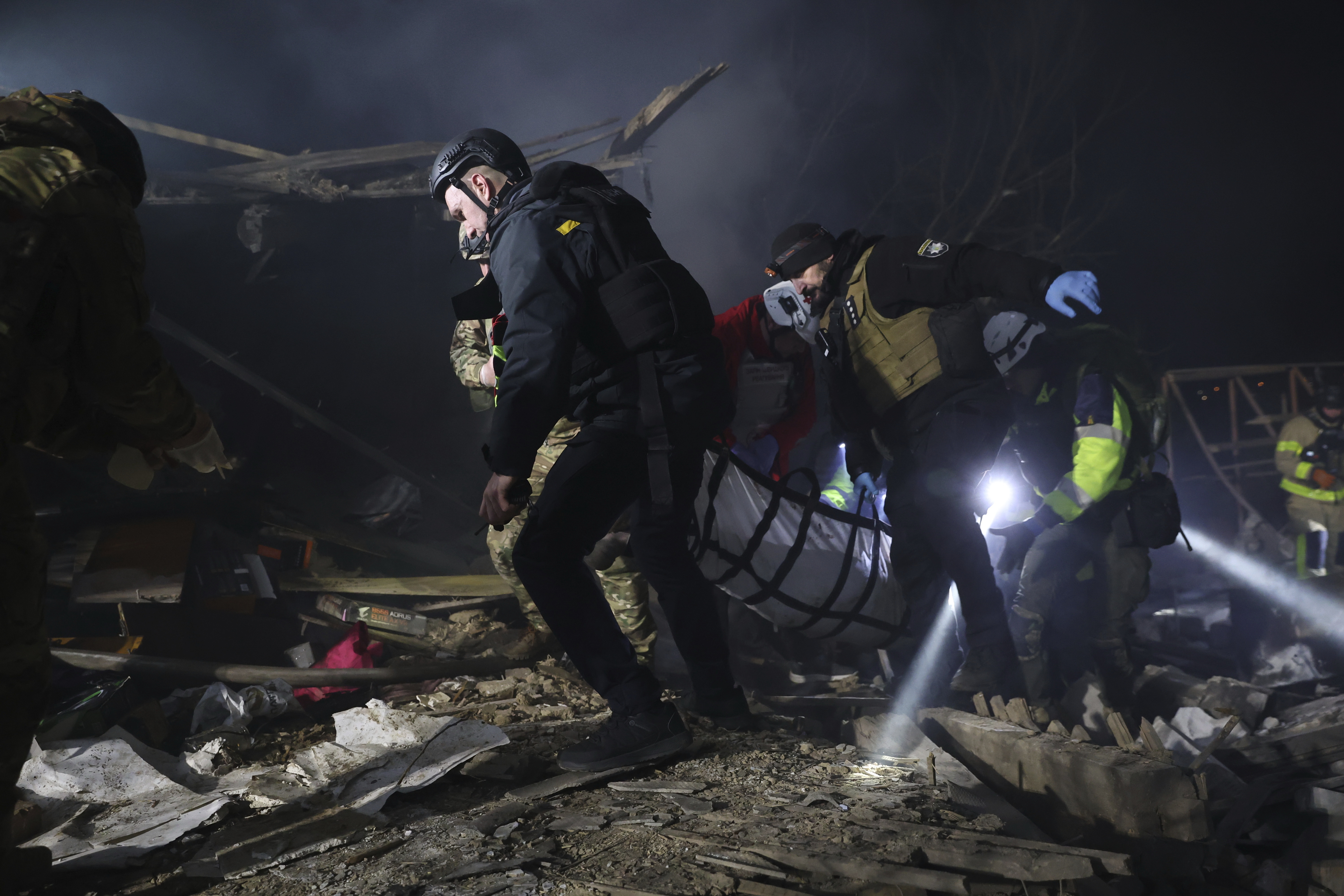 Police officers carry the body of a person killed by a Russian drone strike in a residential neighborhood in Zaporizhzhia, Ukraine, Friday, March 21, 2025. (AP Photo/Kateryna Klochko)