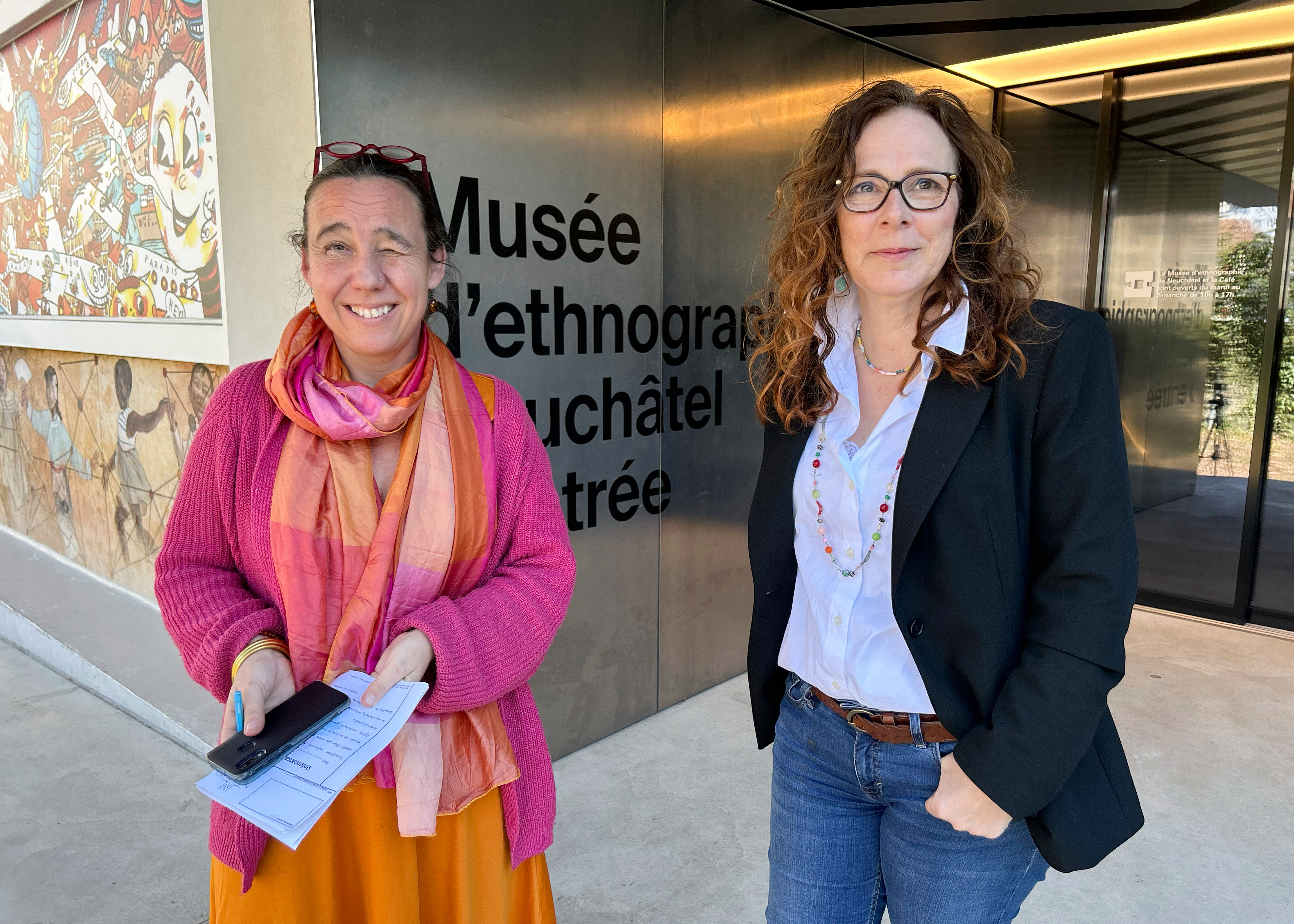 Marianne de Reynier Nevsky, the cultural mediation manager in Neuchatel, left, and town council member Julie Courcier Delafontaine chat about a new "museum prescription" program outside the Ethnographic Museum of Neuchatel in Neuchatel, Switzerland, Wednesday, March 19, 2025. (AP Photo/Jamey Keaton)