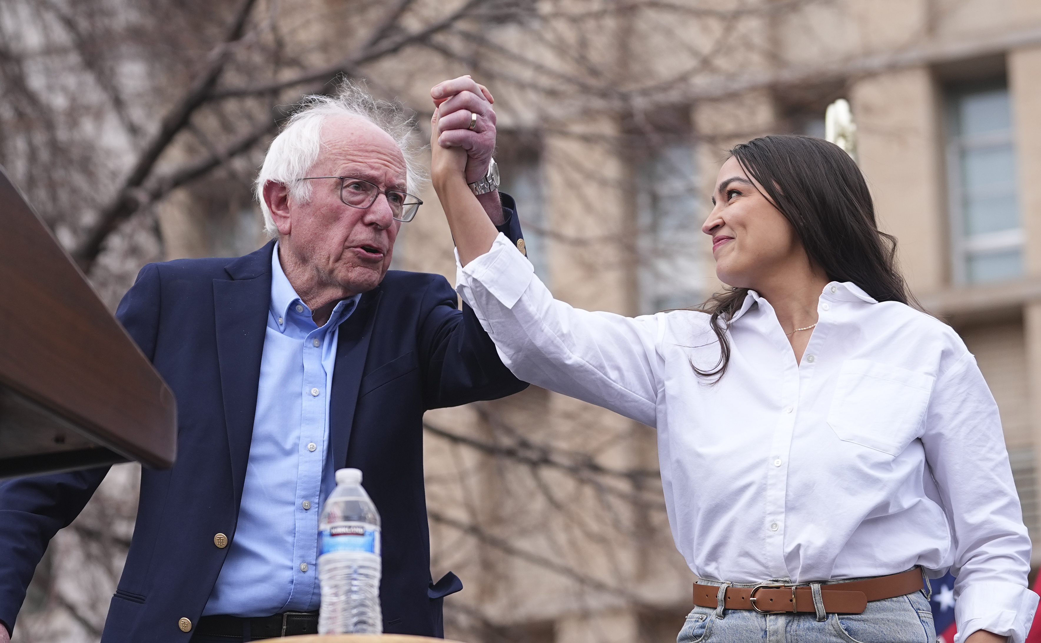 Sen. Bernie Sanders, I-Vt., left, greets Rep. Alexandria Ocasio-Cortez, D-N.Y., as they speak during a stop of their "Fighting Oligarchy" tour that filled Civic Center Park, Friday, March 21, 2025, in Denver. (AP Photo/David Zalubowski)