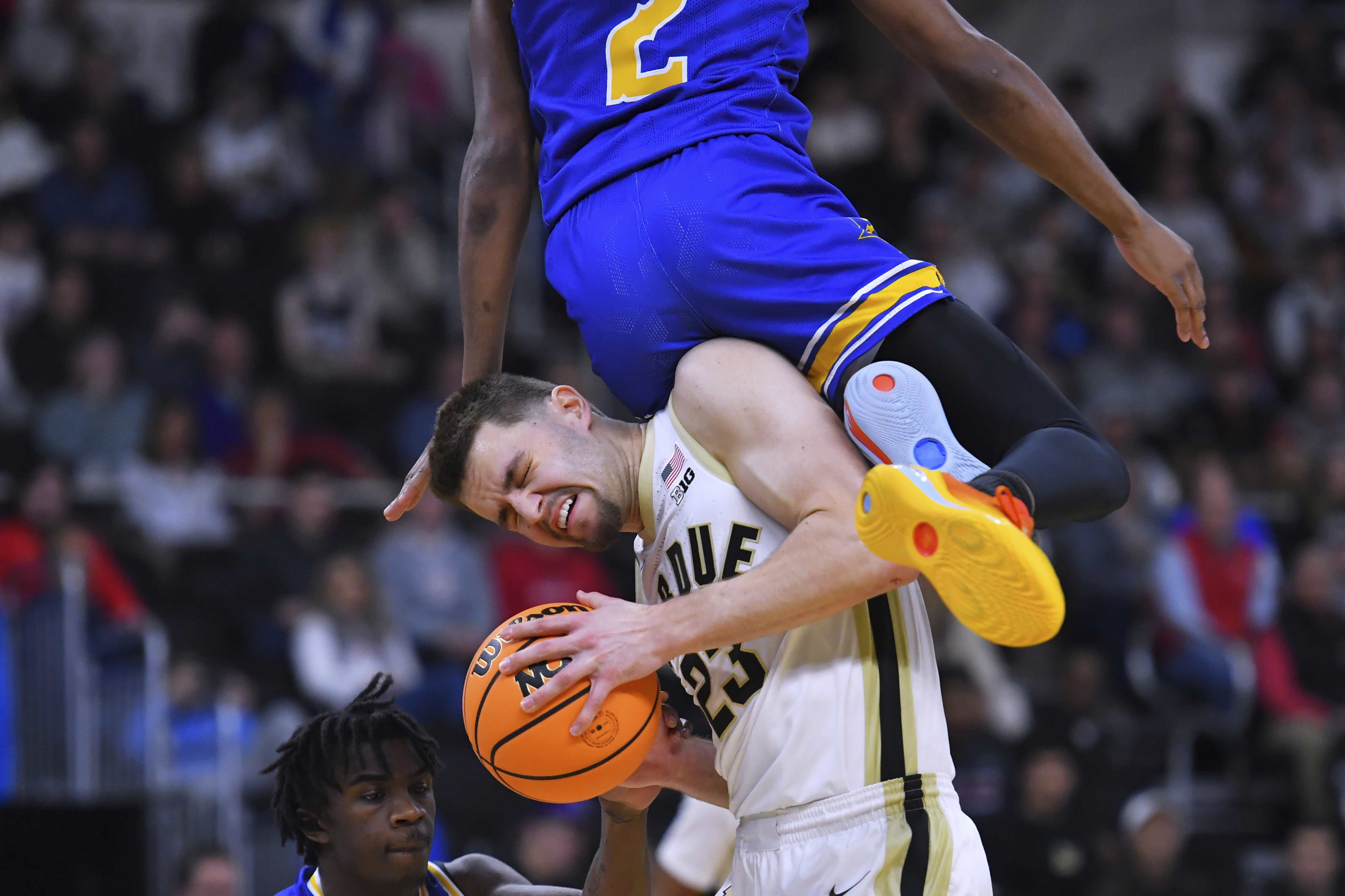 Purdue forward Camden Heide (23) hangs onto the ball while colliding with McNeese State guard DJ Richards Jr. (2) during the first half in the second round of the NCAA college basketball tournament, Saturday, March 22, 2025, in Providence, R.I. (AP Photo/Steven Senne)