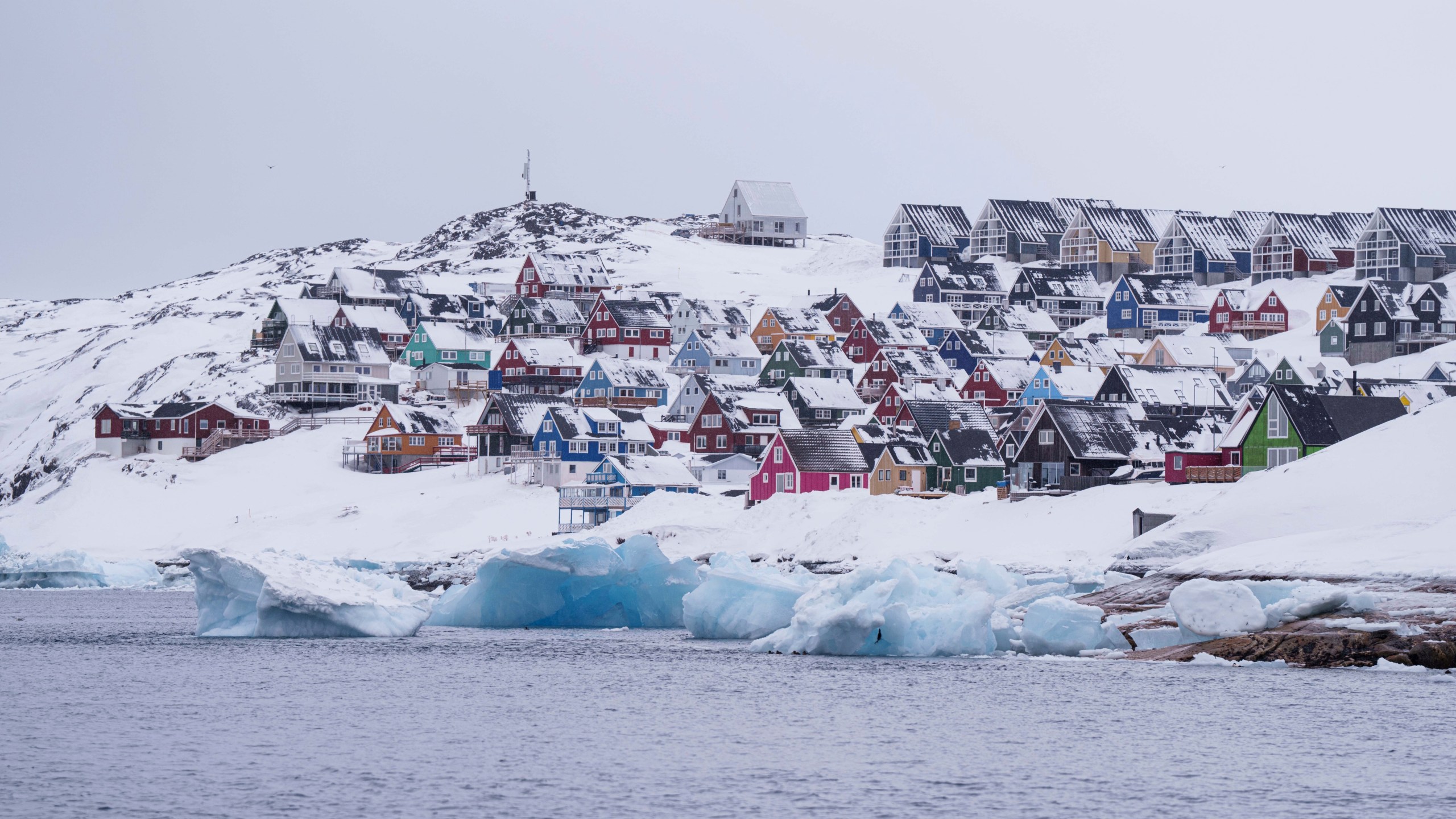 Coloured houses covered by snow are seen from the sea in Nuuk, Greenland, Thursday March 6, 2025. (AP Photo/Evgeniy Maloletka)