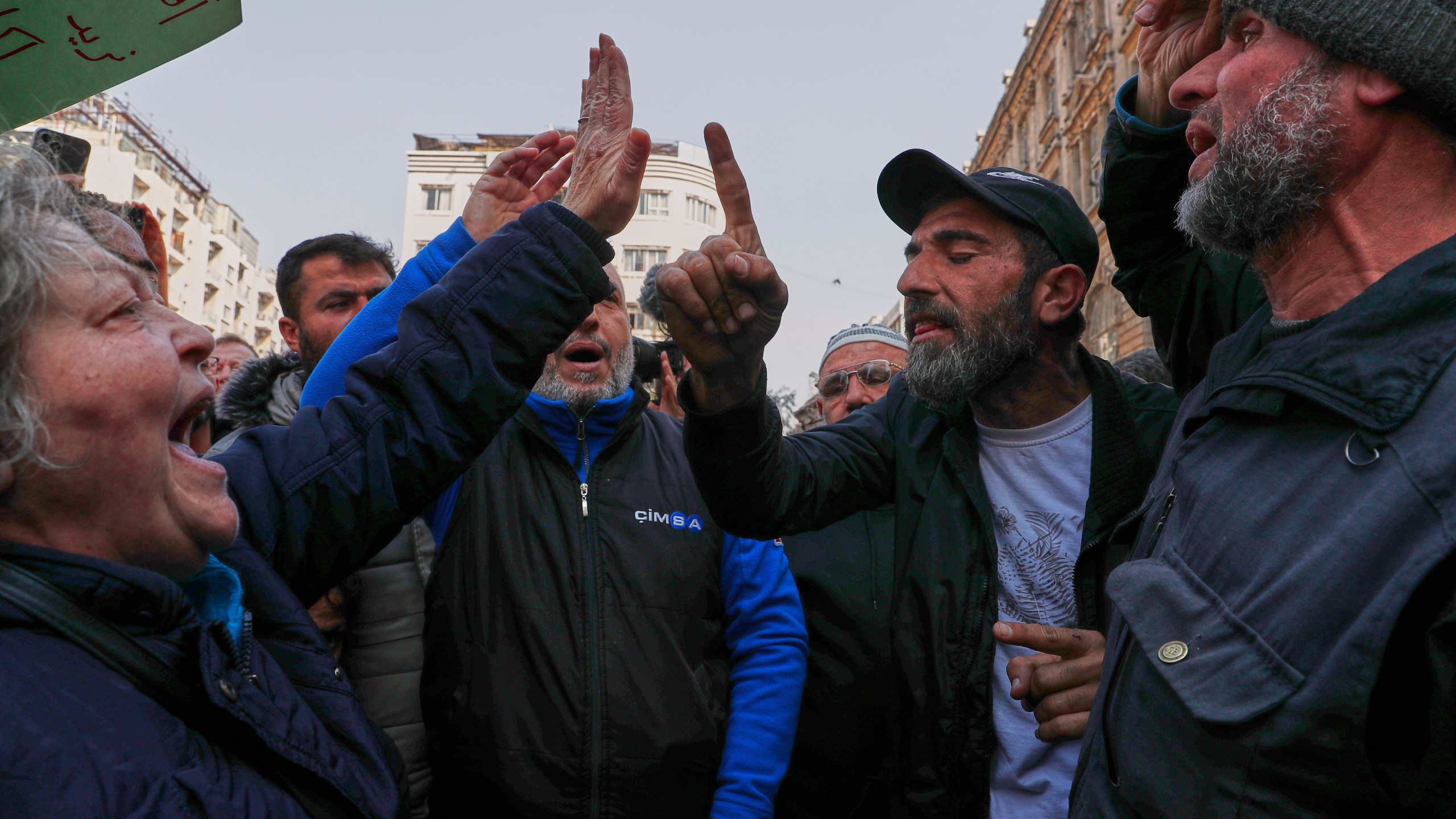 An activist woman protesting against the recent wave of violence and sectarian attacks in Syria's coastal region faces off against a man at Al Marjeh Square in Damascus, Syria, Sunday, March 9, 2025. (AP Photo/Omar Sanadiki)