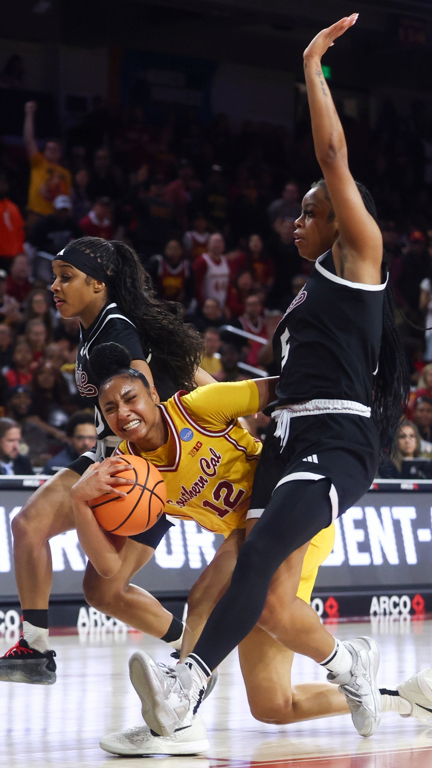 Southern California guard JuJu Watkins (12) draws a foul against Mississippi State guard Eniya Russell, left, and guard Chandler Prater (5) during the first half in the second round of the NCAA college basketball tournament Monday, March 24, 2025, in Los Angeles. (AP Photo/Jessie Alcheh)