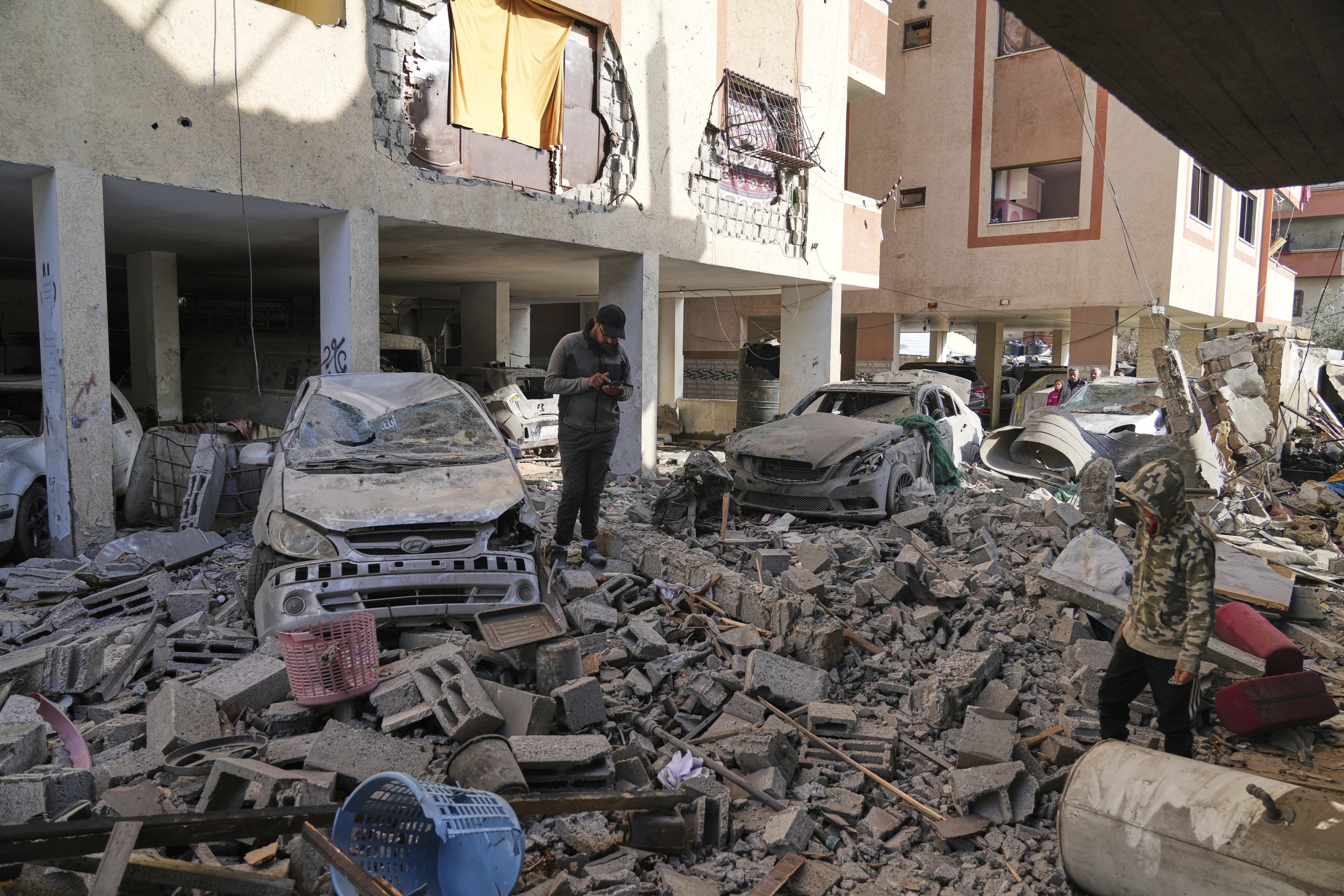 Palestinians inspect the site hit by an Israeli strike in Deir al-Balah, Gaza Strip on Tuesday, March 25, 2025. (AP Photo/Abdel Kareem Hana)