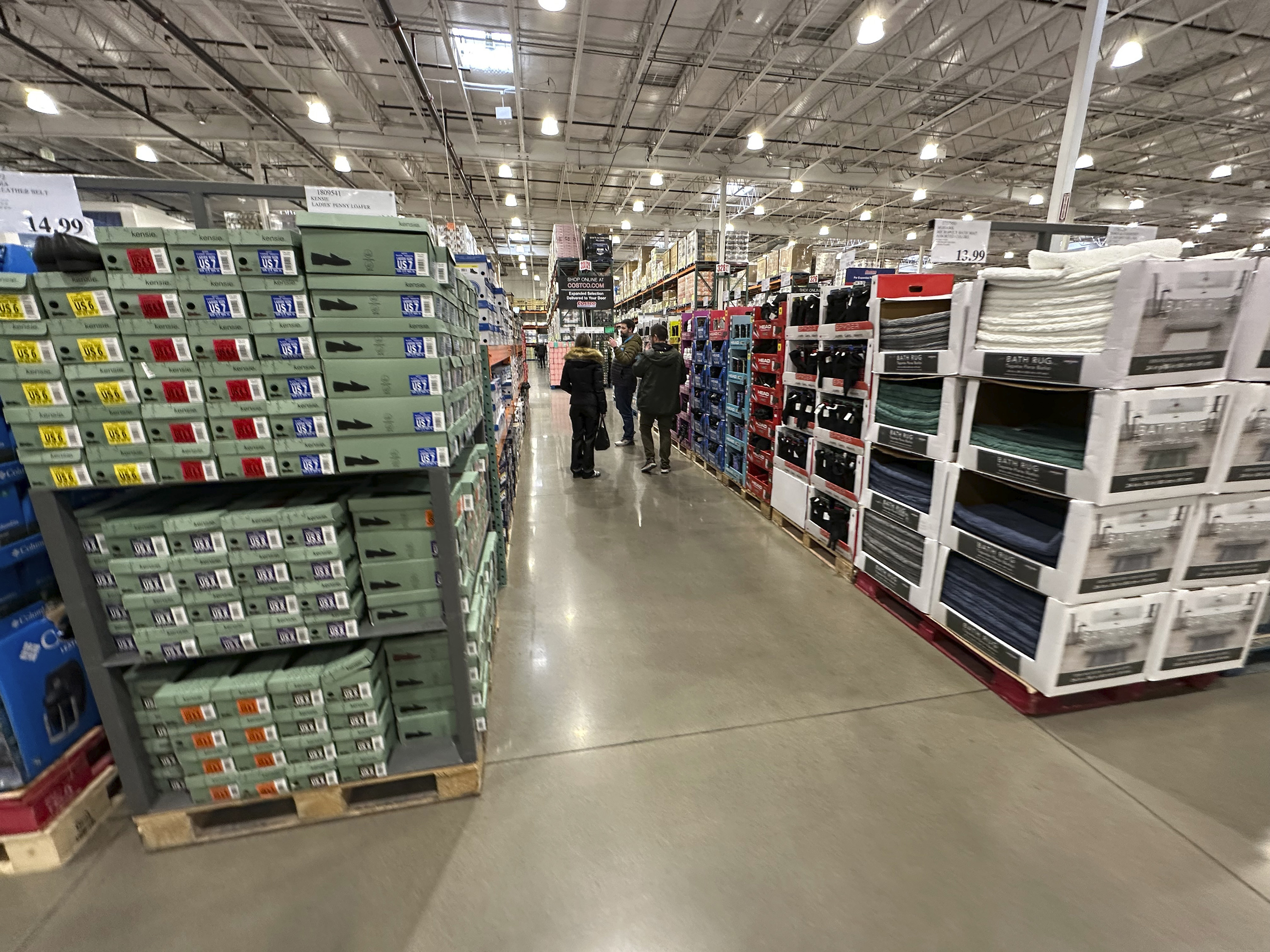 FILE - Shoppers make their ways down an aisle lined with clothing and shoes in a Costco warehouse Thursday, Jan. 23, 2025, in Sheridan, Colo. (AP Photo/David Zalubowski, File)