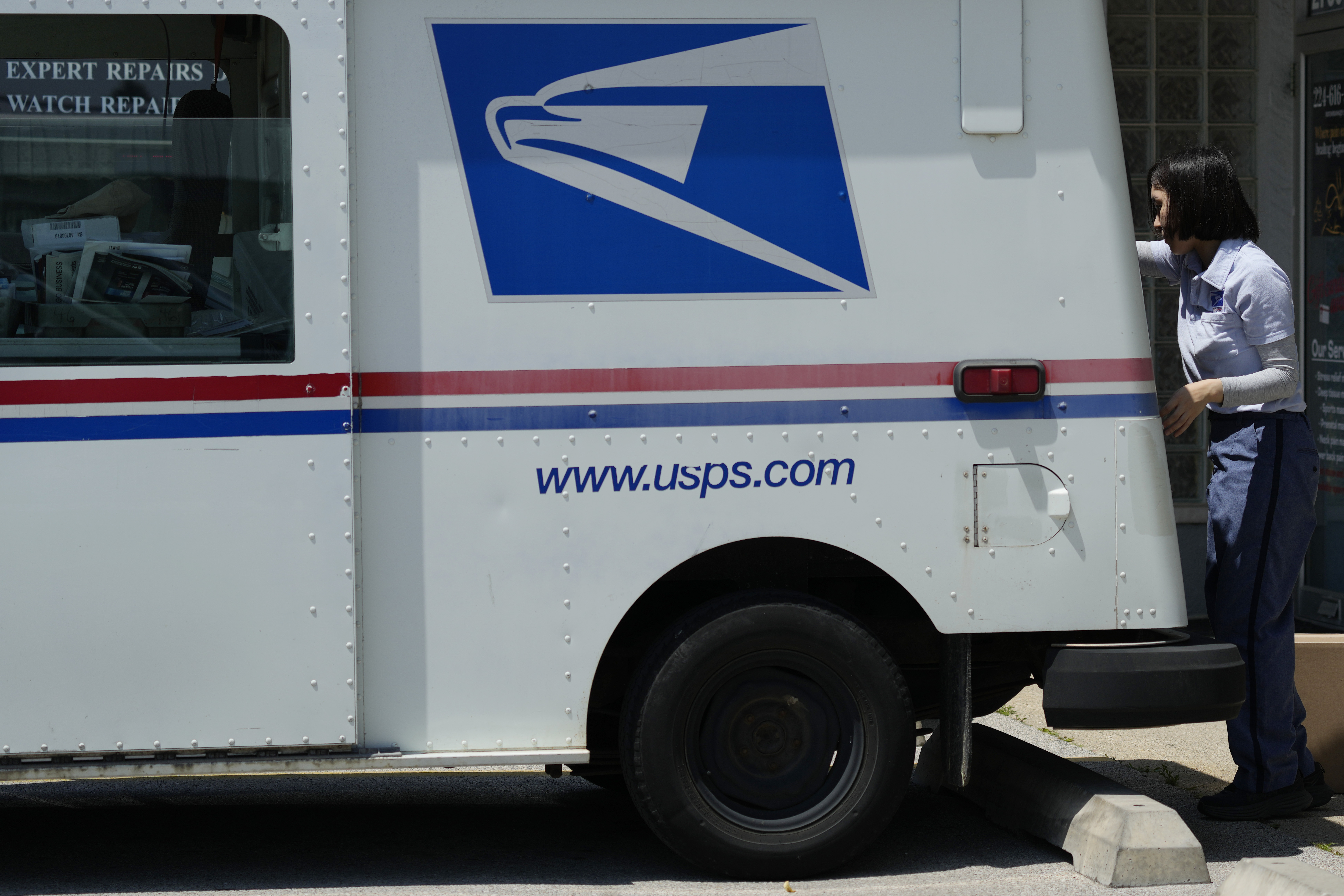 FILE - A U.S. Postal Service employee works outside as she makes deliveries in Northbrook, Ill., Monday, June 3, 2024. (AP Photo/Nam Y. Huh, File)